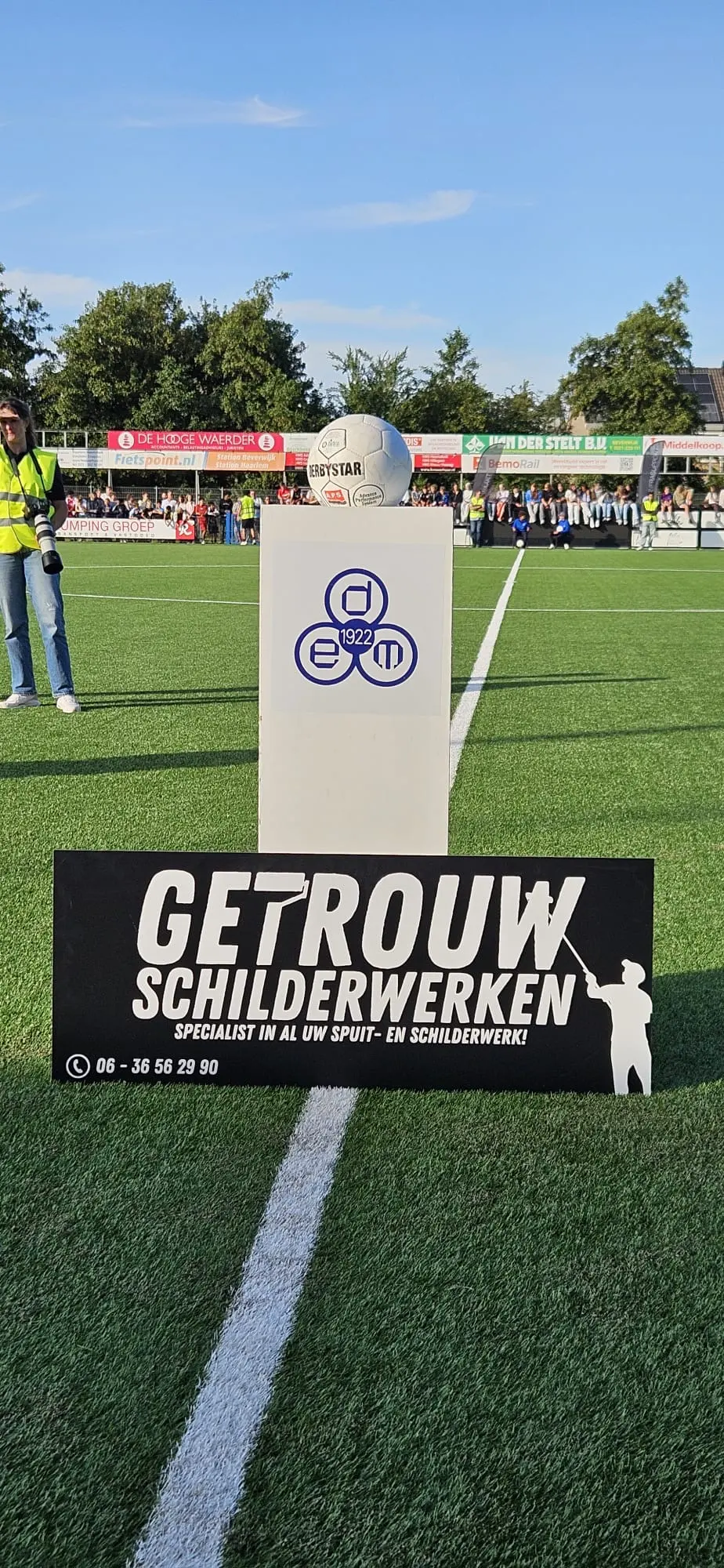 Reclamebord van Getrouw langs het voetbalveld